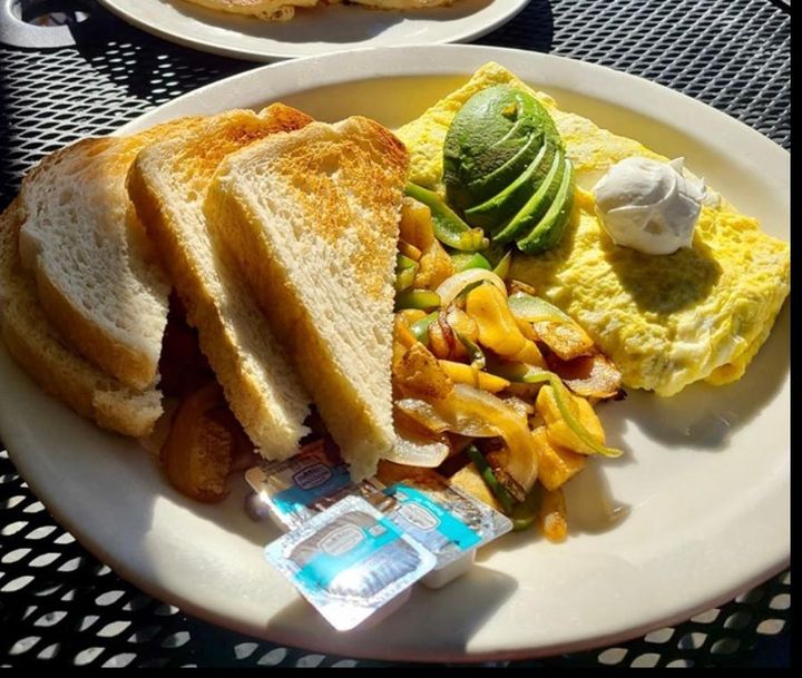 Omelette with avocado, potatoes, and toast at John's